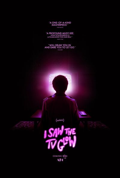 This stylish poster for "I Saw the TV Glow" features Owen (Justice Smith) sitting in a darkened living room, his head silhoutted by the eerie purple glow from a static-covered retro television. The same neon purple color is used for a series of critical accolades at the top of the poster and the title of the film in wavy font at the bottom.
