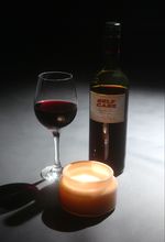 Film poster depicting a bottle of wine with the film's title "SELF CARE", a candle, and a glass of red wine, shot in studio on a black background.